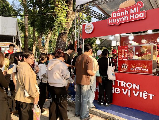 Người dân xếp hàng thưởng thức thương hiệu bánh mì truyền thống nổi tiếng Sài Gòn. Ảnh: Mỹ Phương - TTXVN