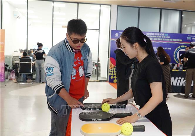 Khách tham quan, tìm hiểu về sản phẩm, thương hiệu trong lĩnh vực thể thao. Ảnh: Thu Hoài - TTXVN