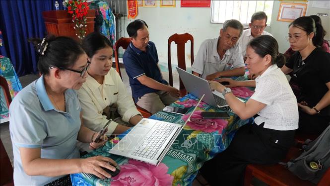 Thành viên Tổ công nghệ số cộng đồng thôn Phương Quý 2, xã Ngọk Bay hướng dẫn người dân nộp hồ sơ thủ tục hành chính trực tuyến. Ảnh: Dư Toán - TTXVN