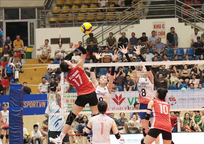 Sau lễ khai mạc, đội nữ Hà Nội Tasco Auto (Áo trắng) gặp Binh chủng Thông tin (Áo đỏ). Ảnh: Tạ Toàn – TTXVN