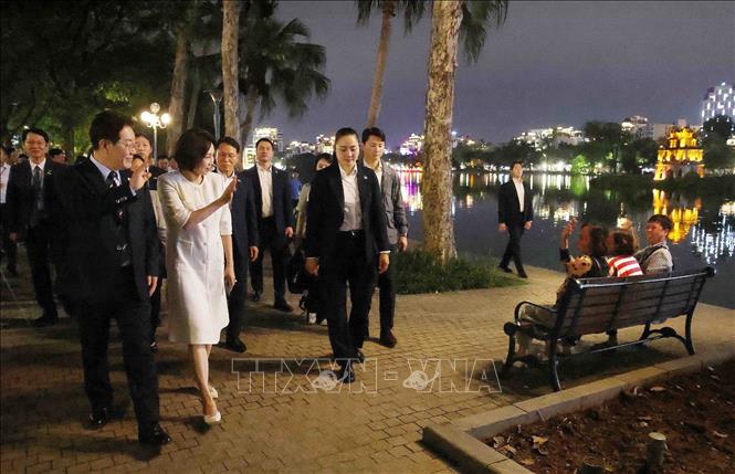 Tổng thống Hàn Quốc Lee Jae Myung và Phu nhân Kim Hae Kyung vẫy chào người dân Thủ đô bên hồ Hoàn Kiếm. Ảnh: Phạm Kiên - TTXVN