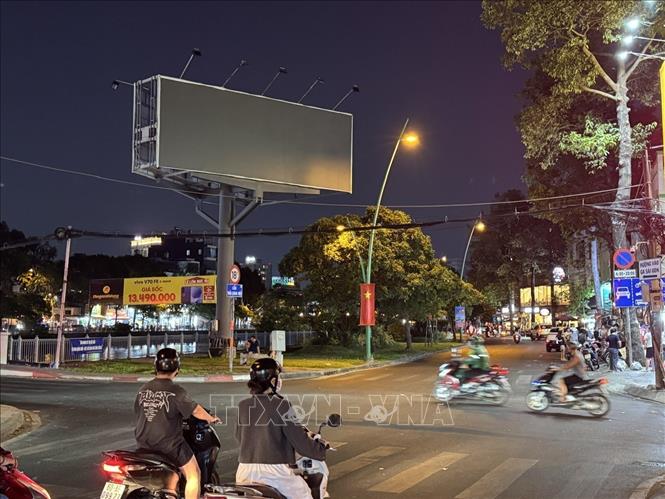 Nhiều bảng hiệu, màn hình LED và hệ thống chiếu sáng trang trí trên đường Hoàng Sa, phường Nhiêu Lộc đã giảm sáng hoặc tắt sau 22 giờ 00. Ảnh: Thanh Vũ-TTXVN
