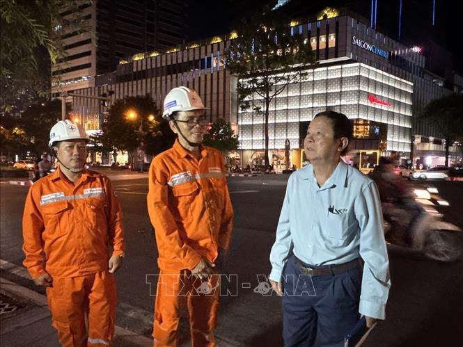 Đại diện Công ty Điện lực Sài Gòn và doanh nghiệp có nhiều bảng hiệu, màn hình LED và hệ thống chiếu sáng trang trí trên đường Lê Lợi, phường Bến Thành thực hiện  tắt sau 22 giờ 00. Ảnh: Thanh Vũ-TTXVN