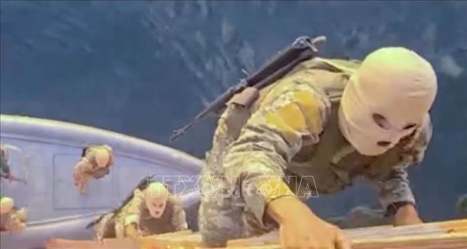 Tình hình tại eo biển Hormuz tiếp tục diễn biến phức tạp khi các vụ tấn công tàu thuyền tái diễn, trong bối cảnh Iran kiên quyết không mở lại tuyến hàng hải chiến lược này nếu Mỹ chưa dỡ bỏ phong tỏa. Ngày 23/4/2026, căng thẳng leo thang sau khi Iran tấn công 3 tàu gần eo biển Hormuz và bắt giữ 2 tàu khác. Iran tuyên bố việc mở lại eo biển Hormuz là “không thể” chừng nào phong tỏa của Mỹ còn tồn tại. Trong ảnh: Ảnh chụp từ video được phát sóng trên truyền hình nhà nước Iran ngày 22/4/2026, cho thấy binh sĩ Iran bắt giữ các tàu container MSC Francesca và Epaminondas tại eo biển Hormuz. Ảnh: REUTERS/TTXVN