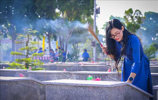 Cán bộ, chiến sĩ các cơ quan, đơn vị thắp hương tại các phần mộ liệt sĩ. Ảnh: Văn Sĩ - TTXVN