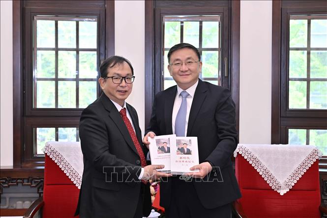 Phó Tổng Giám đốc TTXVN Nguyễn Tuấn Hùng (trái) và đồng chí Nhậm Vệ Đông, Ủy viên Ban Cán sự Đảng, Phó Tổng Biên tập Tân Hoa xã tại buổi làm việc. Ảnh: THX/TTXVN phát