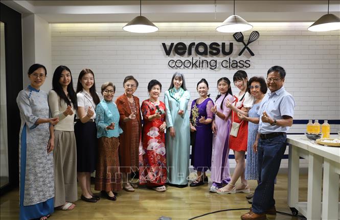 Phu nhân Hồ Thị Thu Trang (áo dài xanh ngọc) chụp ảnh lưu niệm cùng bà con kiều bào tại chương trình. Ảnh: Đỗ Sinh – PV TTXVN tại Thái Lan