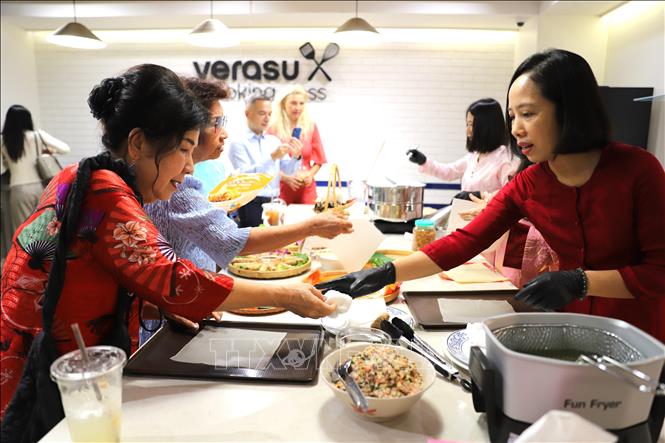 Kiều bào Thái Lan học cách cuốn nem theo hướng dẫn của hội phu nhân, phu quân Đại sứ quán.  Ảnh: Đỗ Sinh – PV TTXVN tại Thái Lan