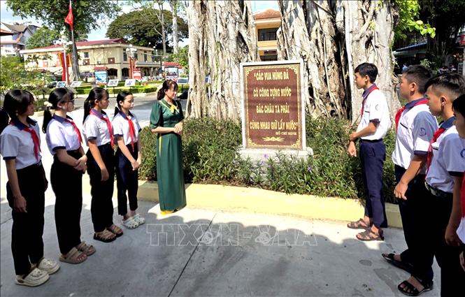 Học sinh nghe thuyết minh về ý nghĩa ngày Giỗ Tổ Hùng Vương và tín ngưỡng thờ cúng Vua Hùng. Ảnh: Lê Thúy Hằng – TTXVN