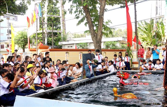 Học sinh phấn khởi xem biểu diễn múa rối nước. Ảnh: Lê Thúy Hằng – TTXVN