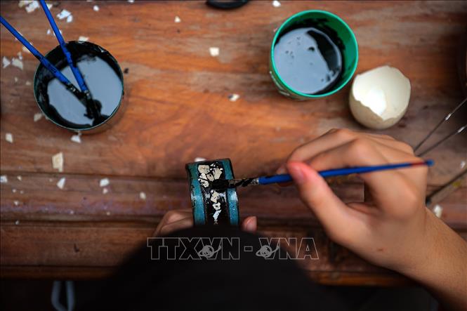 Quét sơn khảm trứng (hay còn gọi là cẩn trứng) là một kỹ thuật độc đáo trong nghệ thuật sơn mài truyền thống Việt Nam, nơi vỏ trứng gà hoặc trứng vịt được xử lý, tạo mảnh và gắn lên bề mặt sản phẩm để tạo hiệu ứng thị giác đặc biệt. Ảnh: Phạm Tuấn Anh - TTXVN