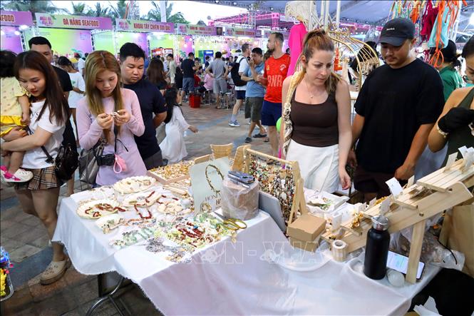 Du khách tham quan mua sắm tại các gian hàng tại chương trình mùa du lịch biển Đà Nẵng. Ảnh: Trần Lê Lâm - TTXVN