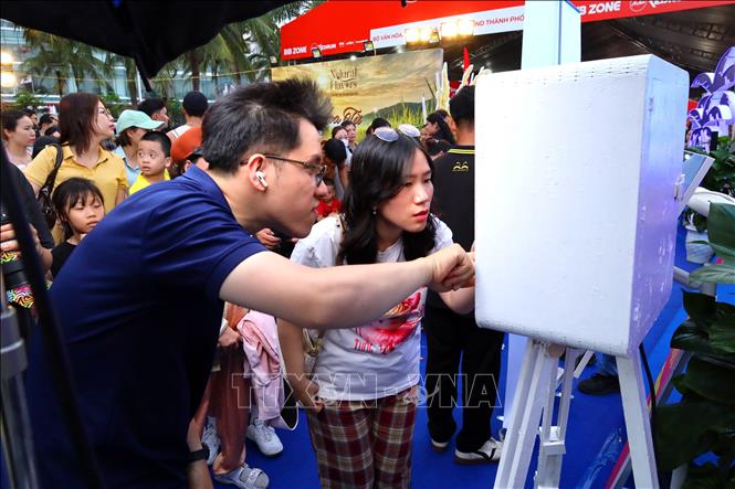 Du khách thích thú chụp ảnh miễn phí tại chương trình. Ảnh: Trần Lê Lâm - TTXVN 