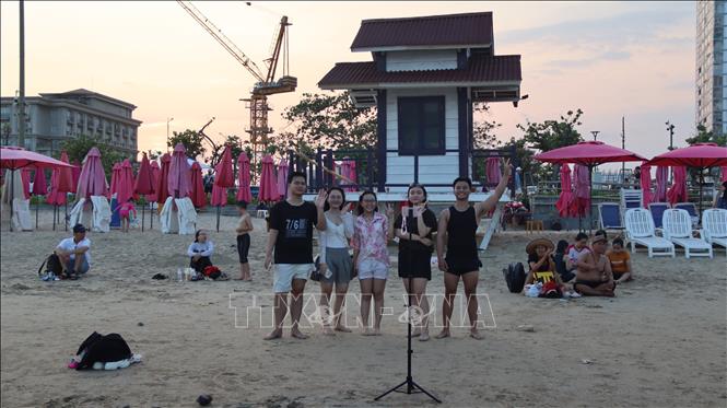 Du khách hào hứng ghi lại những khoảng khắc đẹp trong kỳ nghỉ. Ảnh: Huỳnh Sơn-TTXVN