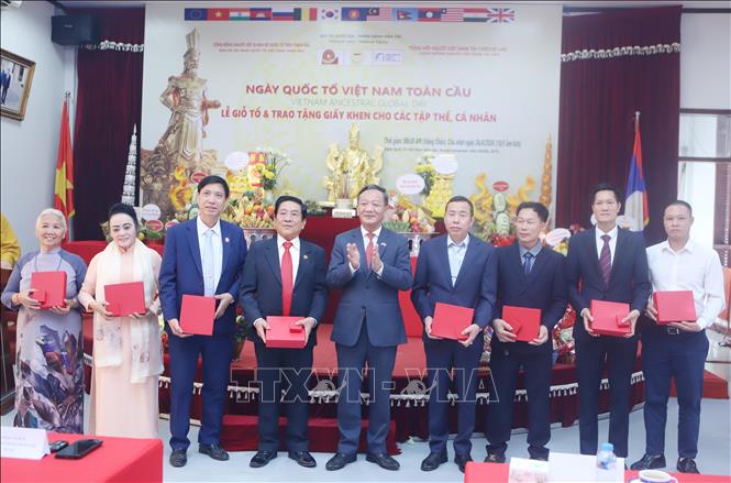 Đại sứ Việt Nam tại Lào Nguyễn Minh Tâm trao tặng Kỷ niệm chương cho các tập thể, cá nhân có công đóng góp tích cực cho hoạt động của Tổng hội người Việt Nam tại Lào nhân dịp Lễ Giỗ Tổ Hùng Vương. Ảnh: Xuân Tú - PV TTXVN tại Lào