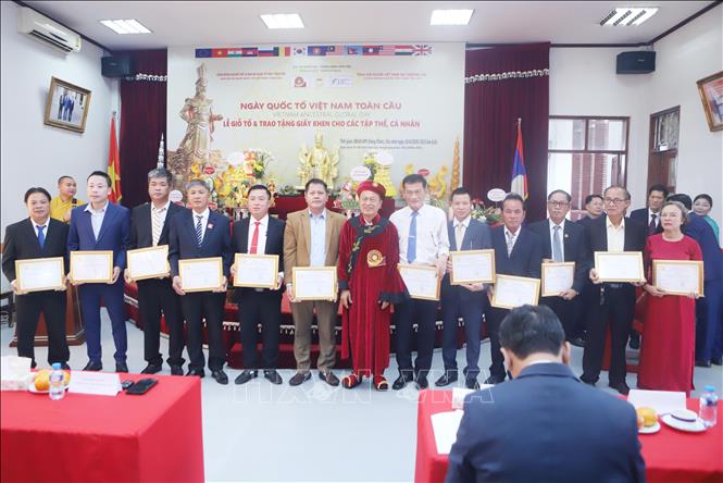 Chủ tịch Tổng hội người Việt Nam tại Lào Phạm Văn Hùng trao giấy khen cho tập thể, cá nhân có thành tích tiểu biểu nhân dịp Lễ Giỗ Tổ Hùng Vương. Ảnh: Xuân Tú - PV TTXVN tại Lào