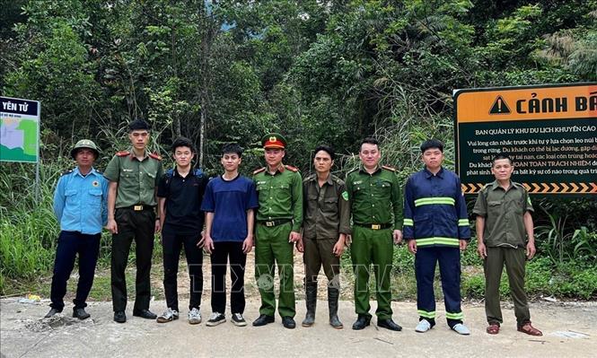 Hai du khách (3 và 4 từ trái qua) chụp ảnh với lực lượng tham gia tìm kiếm. Ảnh: TTXVN phát