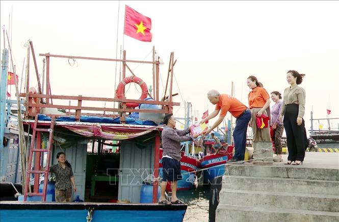 Đại diện “Quỹ Kết nối yêu thương, lan tỏa nhân ái” trao tặng cờ Tổ quốc tiếp thêm động lực vươn khơi cho ngư dân phường Bắc Gianh,  tỉnh Quảng Trị. Ảnh: Tá Chuyên – TTXVN
