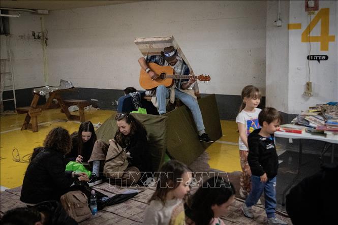 Người dân trú ẩn để tránh các cuộc tấn công tại Tel Aviv, Israel. Ảnh: THX/TTXVN