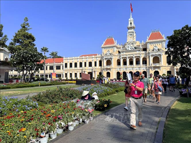 Du khách trong và ngoài nước tham quan, chụp ảnh lưu niệm tại vườn hoa công viên Tượng đài Bác Hồ (phố đi bộ Nguyễn Huệ) tạo nên khung cảnh nhộn nhịp trong ngày nghỉ lễ truyền thống của dân tộc. Ảnh: Thanh Vũ-TTXVN
