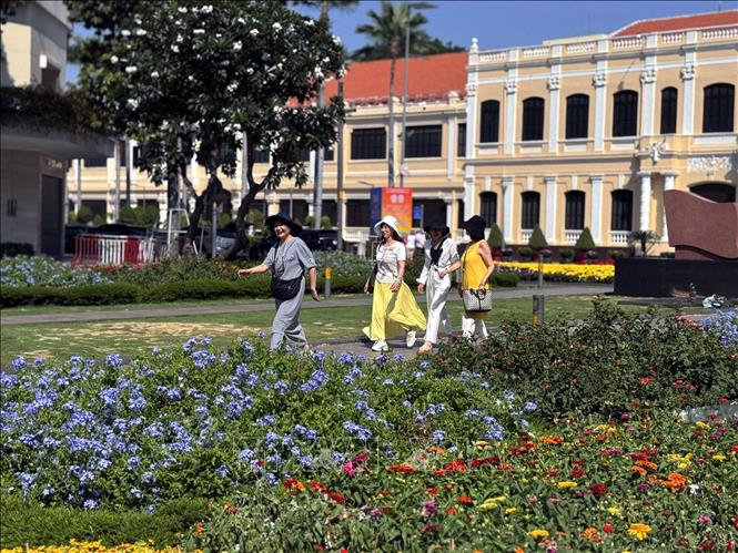 Du khách trong và ngoài nước tham quan, chụo ảnh lưu niệm tại vườn hoa công viên Tượng đài Bác Hồ (phố đi bộ Nguyễn Huệ) tạo nên khung cảnh nhộn nhịp trong ngày nghỉ lễ truyền thống của dân tộc. Ảnh: Thanh Vũ-TTXVN
