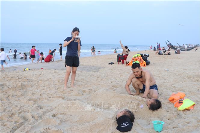 Các gia đình trẻ vui chơi trên cát. Ảnh: Mai Trang - TTXVN