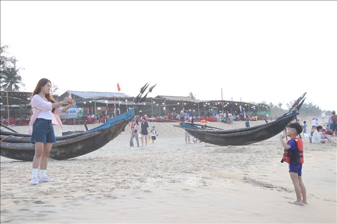 Du khách lưu giữ những khoảng khắc đẹp bên bờ biển Huế. Ảnh: Mai Trang - TTXVN