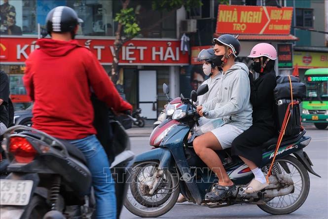 Người dân với đồ đạc, vali được chằng buộc cẩn thận di chuyển từ hướng phía Nam vào Hà Nội. Ảnh: Hoàng Hiếu - TTXVN