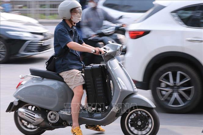 Người dân với vali di chuyển vào thành phố. Ảnh: Hoàng Hiếu - TTXVN