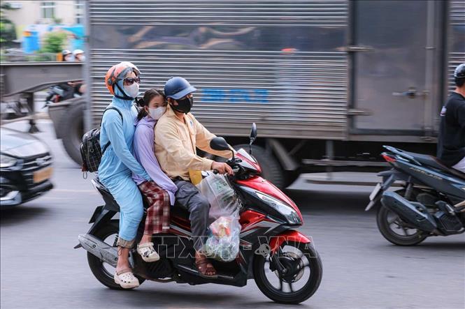 Một gia đình di chuyển từ hướng Quốc lộ 1A vào Hà Nội. Ảnh: Hoàng Hiếu - TTXVN