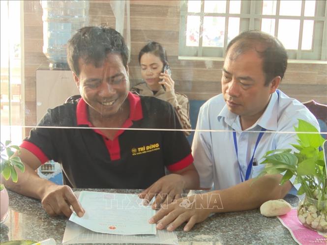 Cán bộ Trung tâm Phục vụ hành chính công xã Tân Quan hướng dẫn người dẫn người dân thực hiện thủ tục hành chính. Ảnh: K GỬIH-TTXVN  