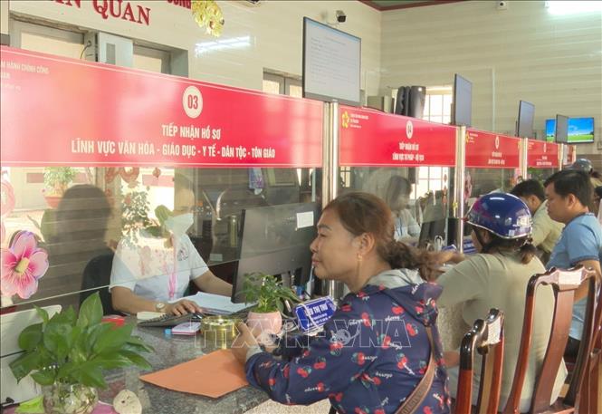 Người dân thực hiện thủ tục hành chính công tại Trung tâm Phục vụ hành chính công xã Tân Quan. Ảnh: K GỬIH-TTXVN  