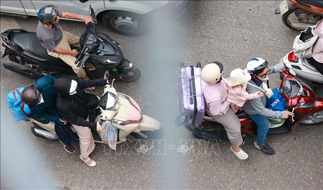 Lỉnh kỉnh đồ đạc, hành lý, người dân trở lại Thủ đô bằng xe gắn máy. Ảnh: Thanh Tùng - TTXVN