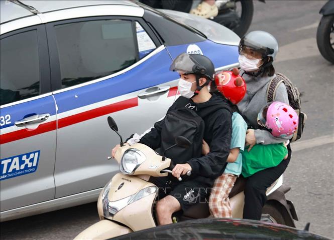 Lỉnh kỉnh đồ đạc, hành lý, người dân trở lại Thủ đô bằng xe gắn máy. Ảnh: Thanh Tùng - TTXVN