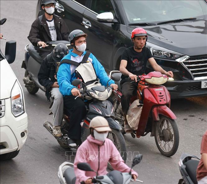 Lỉnh kỉnh đồ đạc, hành lý, người dân trở lại Thủ đô bằng xe gắn máy. Ảnh: Thanh Tùng - TTXVN