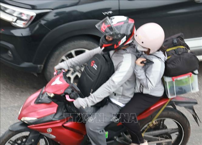 Lỉnh kỉnh đồ đạc, hành lý, người dân trở lại Thủ đô bằng xe gắn máy. Ảnh: Thanh Tùng - TTXVN