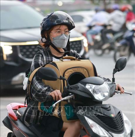 Lỉnh kỉnh đồ đạc, hành lý, người dân trở lại Thủ đô bằng xe gắn máy. Ảnh: Thanh Tùng - TTXVN