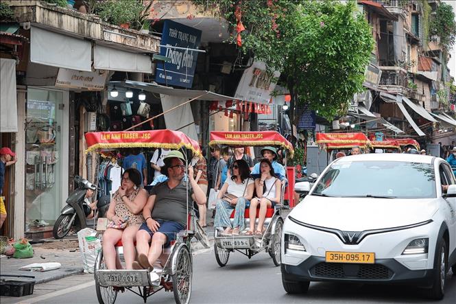 Tourists visit Old Quarter in Hanoi with xich lo (cyclo). VNA Photo: Phạm Tuấn Anh