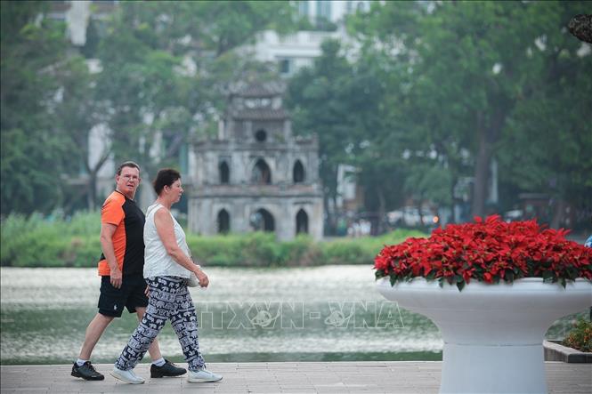 Tourists take a walk around Hoan Kiem Lake. VNA Photo: Phạm Tuấn Anh