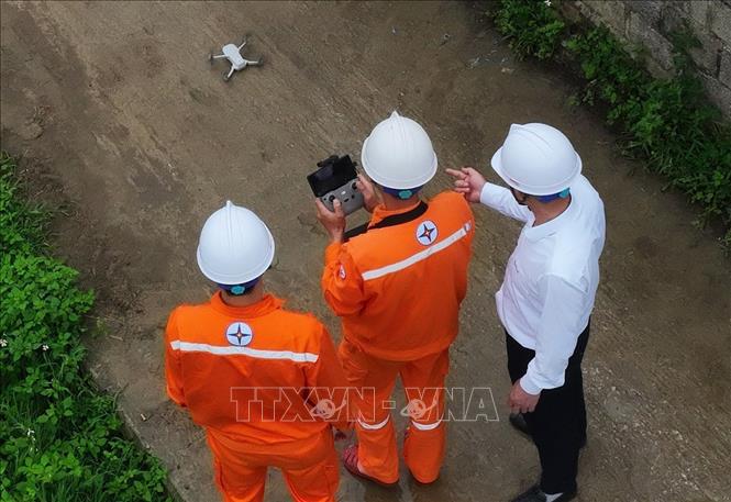 Công nhân ngành điện sử dụng thiết bị bay không người lái (flycam) camera nhiệt kiểm tra đường dây của hệ thống lưới điện xã Bắc Sơn, tỉnh Lạng Sơn. Ảnh: Vũ Sinh - TTXVN