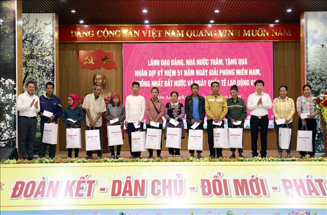 Phó Chủ tịch Trung ương Hội Nông dân Việt Nam Nguyễn Xuân Định và Phó Bí thư Tỉnh ủy, Chủ tịch Ủy ban nhân dân tỉnh Sơn La Nguyễn Đình Việt tặng quà cho các hộ nghèo, gia đình có hoàn cảnh khó khăn. Ảnh: Quang Quyết - TTXVN