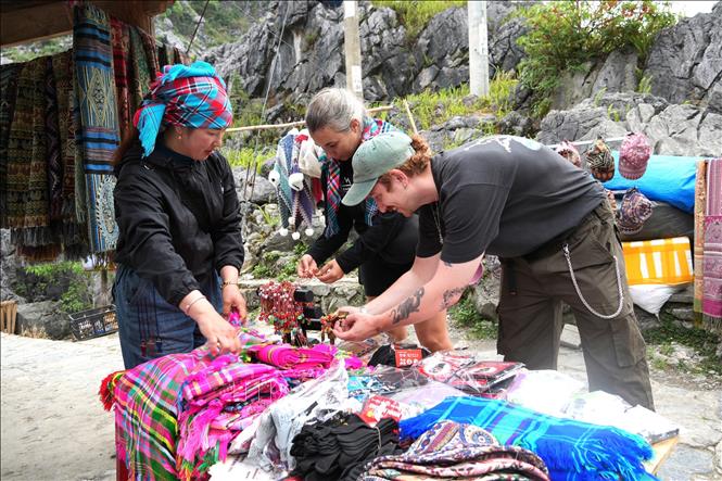 Du khách châu Âu trải nghiệm sản phẩm thổ cẩm tại Cao nguyên đá Đồng Văn. Ảnh: Minh Tâm-TTXVN
