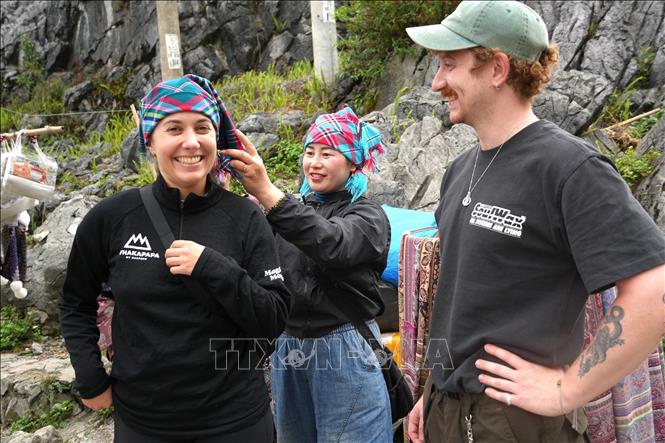 Du khách châu Âu thích thú thử trang phục truyền thống cùng người dân bản địa trên Cao nguyên đá Đồng Văn. Ảnh: Minh Tâm-TTXVN