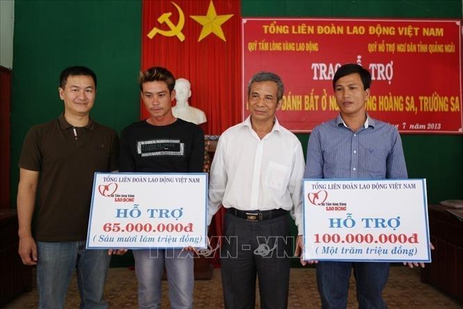 Chủ tịch Tổng Liên đoàn Lao động Việt Nam Đặng Ngọc Tùng trao tượng trưng tiền hỗ trợ ngư dân xã An Vĩnh, huyện Lý Sơ (Quảng Ngãi). Ảnh: Lâm Khánh - TTXVN