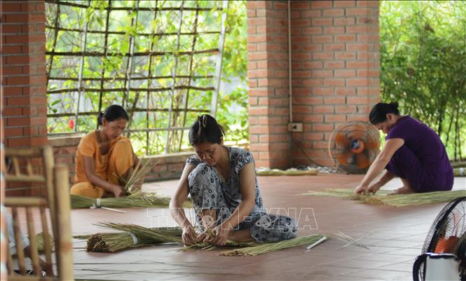 Local villagers in Pho Trach weave mats and products from Bang grass. VNA Photo: Văn Dũng