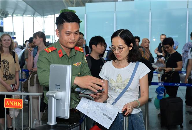 Lực lượng an ninh hàng không kiểm tra giấy tờ, thông tin hành khách trước khi vào khu vực chờ ra cửa lên máy bay. Ảnh: Quốc Khánh - TTXVN