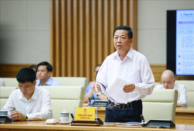 Bộ trưởng Bộ Xây dựng Trần Hồng Minh báo cáo kết quả thực hiện nhiệm vụ của ngành xây dựng. Ảnh: Dương Giang – TTXVN
