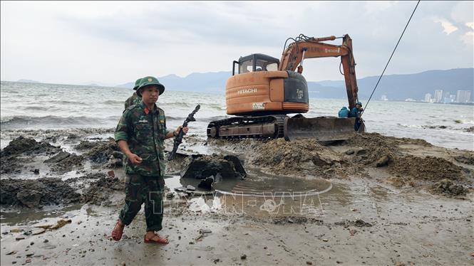 Tiến hành trục vớt vật thể giống xác xe tăng trồi lên ở biển Quy Nhơn. Ảnh: Sỹ Thắng-TTXVN