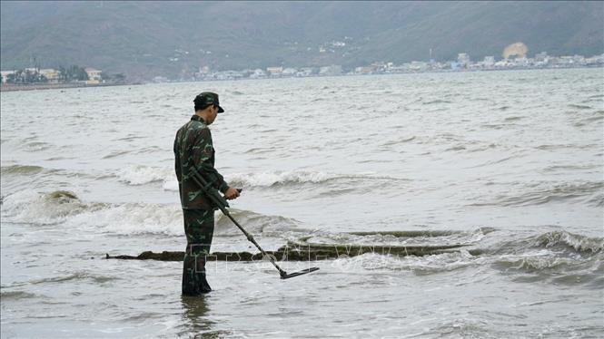 Rà bom mìn truớc khi trục vớt. Ảnh: Sỹ Thắng-TTXVN