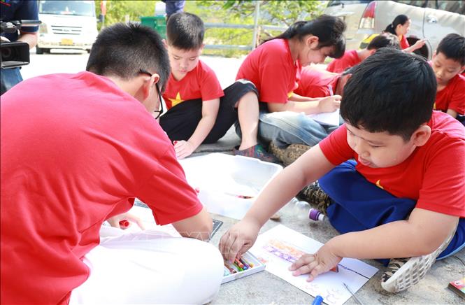 Học sinh tham gia trải nghiệm vẽ tàu C235 tại địa điểm lưu niệm sự kiện Tàu C235 (đường Hồ Chí Minh trên biển), phường Đông Ninh Hòa. Ảnh: Phan Sáu - TTXVN